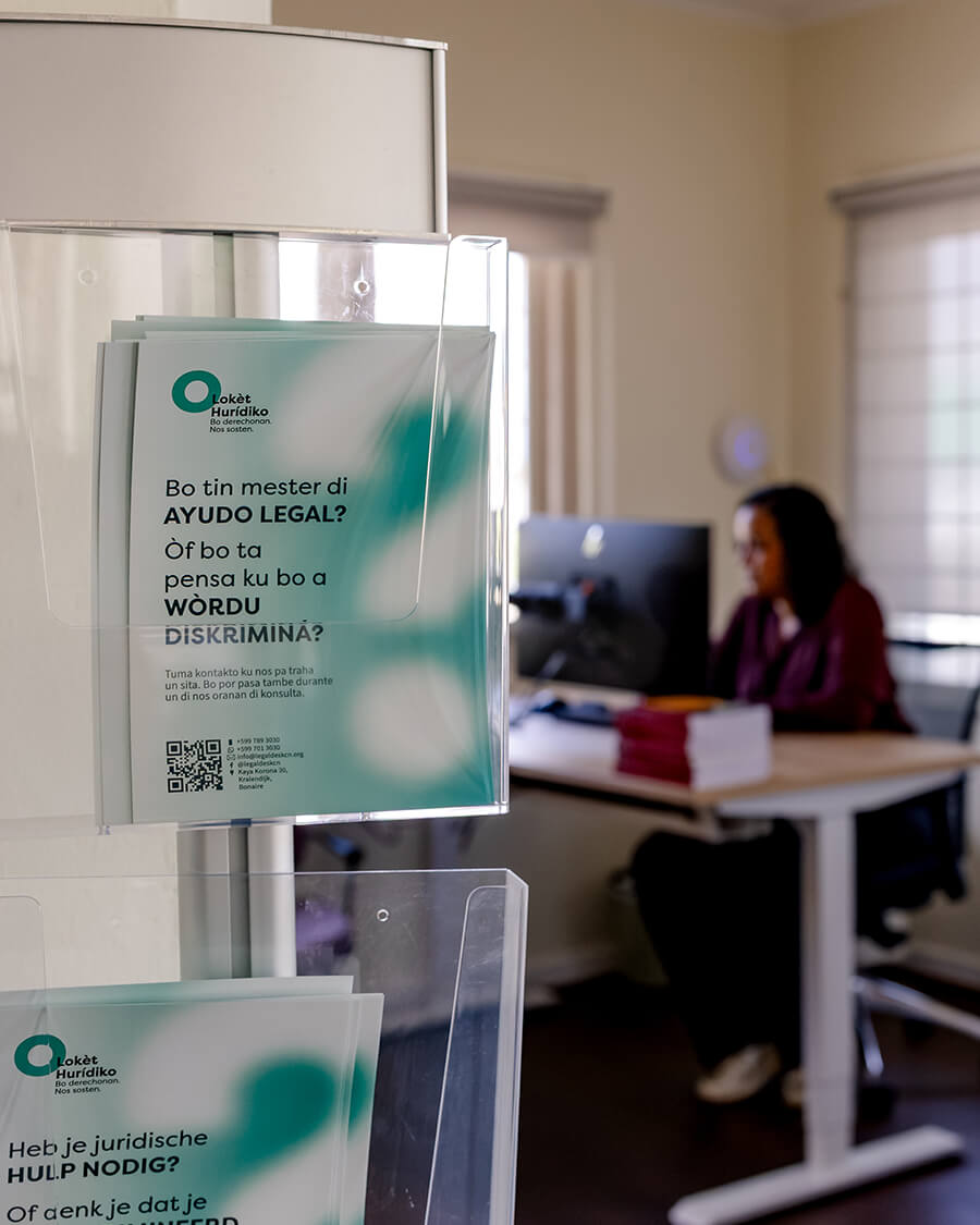 Our mission — Lokèt Hurídiko information leaflets in the office, with a staff member working in the background.