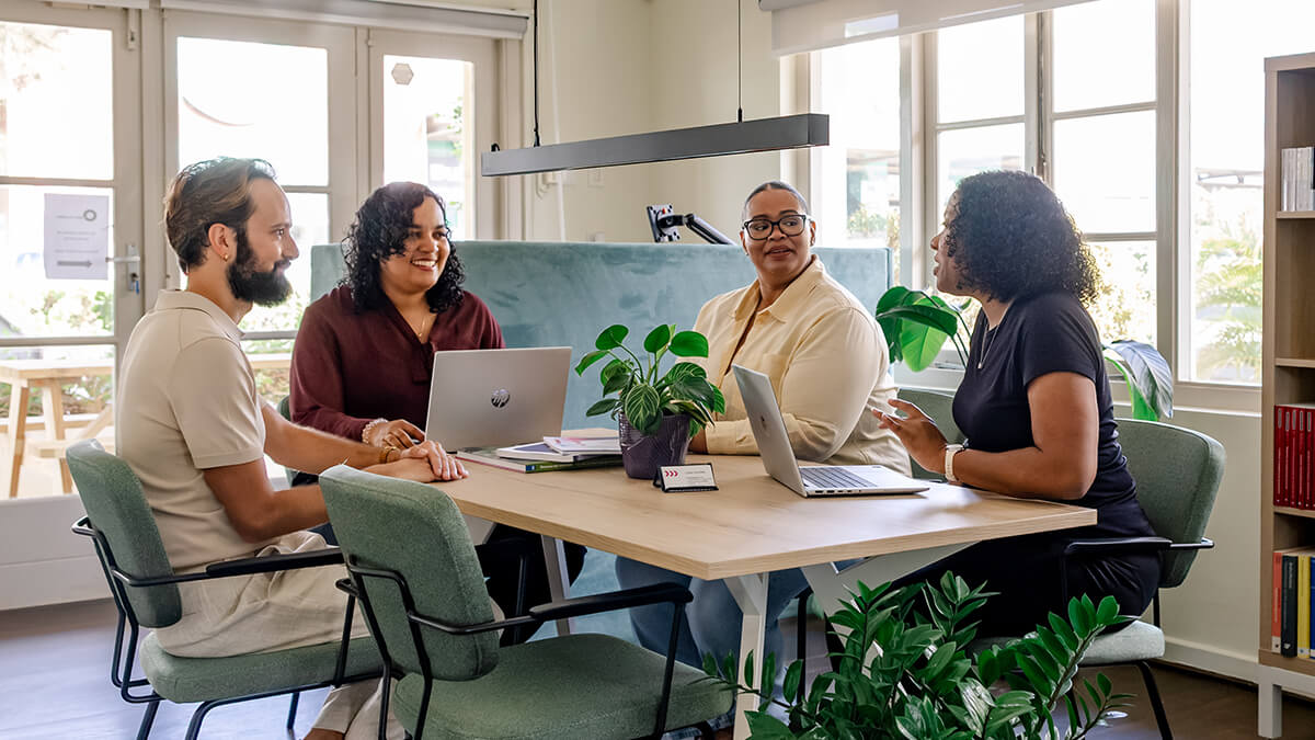 Have a question — the Lokèt Hurídiko team talking with residents around a table in the office.