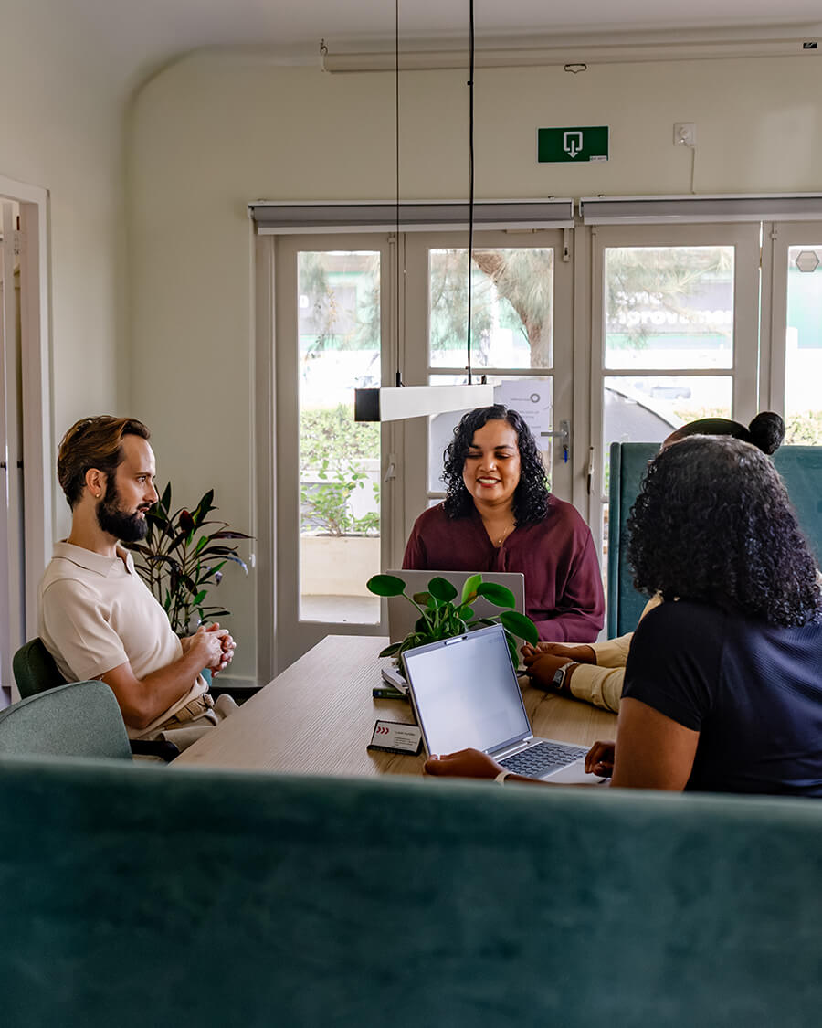 Who we are — the Lokèt Hurídiko team meeting around a table with a resident.
